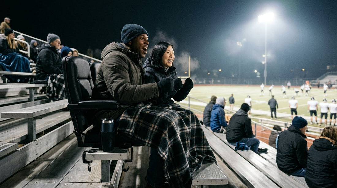 Fans on padded stadium seats at a high school football game at night